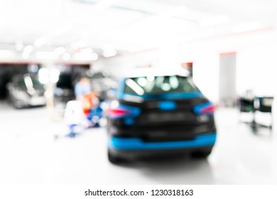 Blurred Abstract Image Of Man Worker With Car In Body Shop. Blur Car Auto Service. Car Bokeh. Blurred Background With Car In Garage. Vehicle Maintenance In Auto Repair Service. Blurry Service Station