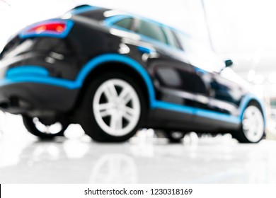 Blurred Abstract Image Of Man Worker With Car In Body Shop. Blur Car Auto Service. Car Bokeh. Blurred Background With Car In Garage. Vehicle Maintenance In Auto Repair Service. Blurry Service Station