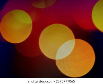 A blurred abstract image of overlapping, multicolored circles against a dark background.