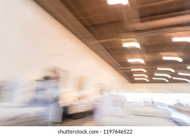 Blurred Abstract Low Angle View To Ceiling At Asian Furniture And Appliances Showroom Mega Retail Store In Texas, USA. Rows Of High-end Sofa And Living Room Supplies