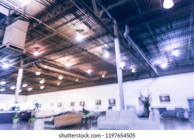 Blurred Abstract Low Angle View To Ceiling At Asian Furniture And Appliances Showroom Mega Retail Store In Texas, USA. Rows Of High-end Sofa And Living Room Supplies