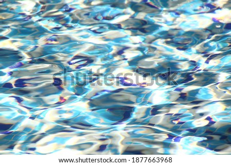 Blurred abstract pattern of light blue and white colors. Deformation of tile pattern in the indoor swimming pool under the water. Waves. Op-art. Purity and cleanliness. Fluid art. Reflection of sun. 