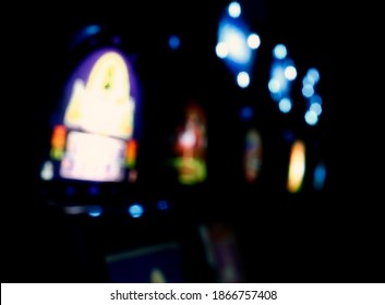 A Blurred Anonymized Shot Of A Slot Machine - Video Poker Room, With Colorful Lights Glowing In The Dark. Soft Pleasant Bokeh.
