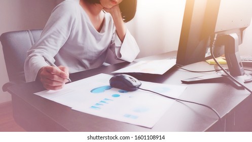 Blurred Asian Woman Is Writing Something On Paper Work Or Presentation To Remind The Meeting, Data Preparation, Take Remark Of Protect For Mistake Or Get Information For Marketing Online. Work At Home