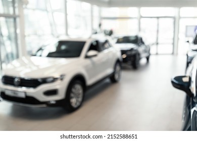 Blurred Automobile Dealership Store Interior With New Luxury Cars, Empty Space. Modern Showroom With Cars For Sale, Defocused Shot. Vehicle Purchase, Rental, Lease Concept