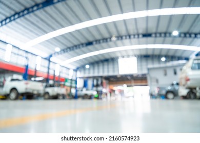 Blurred Of Automotive Industry, Car Repair Service Center The Epoxy Floor In Car Factory Service , The Interior Of A Big Industrial Building Or Factory With Steel Constructions. Steel Roof Frame.