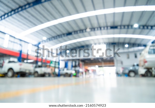 Blurred of Automotive industry, Car repair service\
center the epoxy floor in car factory service , The interior of a\
big industrial building or factory with steel constructions. Steel\
roof frame.