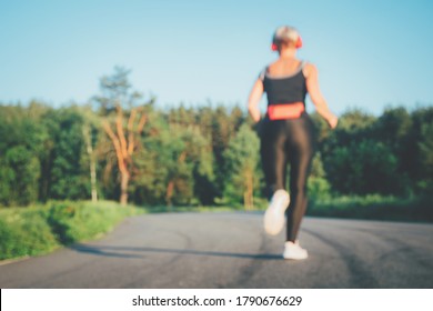 Blurred Back View Of  Jogging Senior Woman Silhouette Running On A Road Outdoor. Out Of Focus Background. Real Life Moments. Back View. Copy Space.