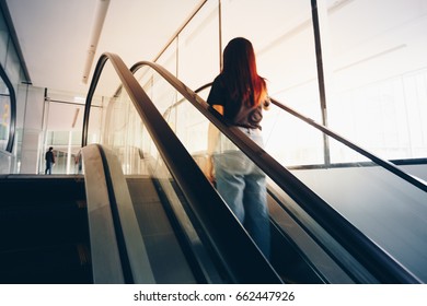 Blurred Back View Woman Going Up The Escalator