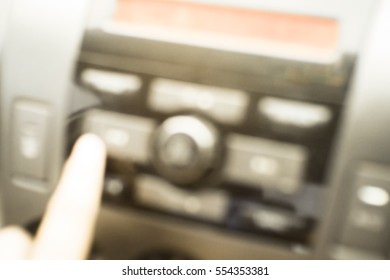 Blurred  background abstract and can be illustration to article of hand adjusting the sound volume in the car stereo