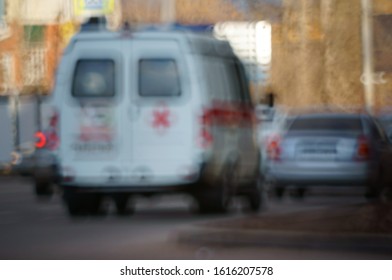 Blurred Background. An Ambulance Is Driving Down The Street Of The City.