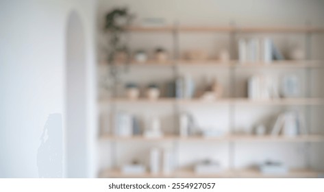 Blurred background of a beautifully arranged shelf in a modern living space showcasing plants, minimalistic vases, and a curated selection of books, all bathed in soft natural light. - Powered by Shutterstock