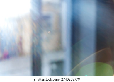 Blurred background with bokeh effect and sun glare. Blurred window view from interior with subtle blue accent
