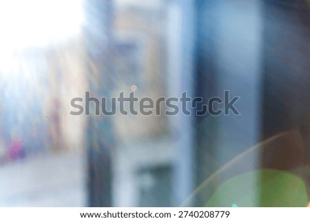 Blurred background with bokeh effect and sun glare. Blurred window view from interior with subtle blue accent