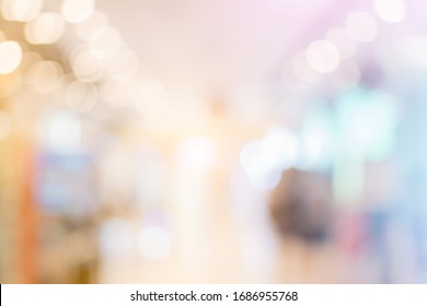 Blurred background with bokeh light in luxury fashion shopping mall with shop window and display modern model  from stores with women and men customer walking in walkway hallway in department 