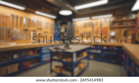 Blurred background of a bright and organized workshop featuring various tools on the walls, a central workbench, and ample storage for an efficient diy environment.