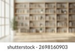 Blurred background of bright and spacious interior featuring wooden bookshelves filled with books and indoor plants, creating a serene environment perfect for reading or studying in natural light.