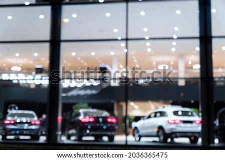 Blurred background with car dealership exterior. Abstract blurred photo of modern building motor showroom. Blur car show room office bokeh lights. Automobile retail shop