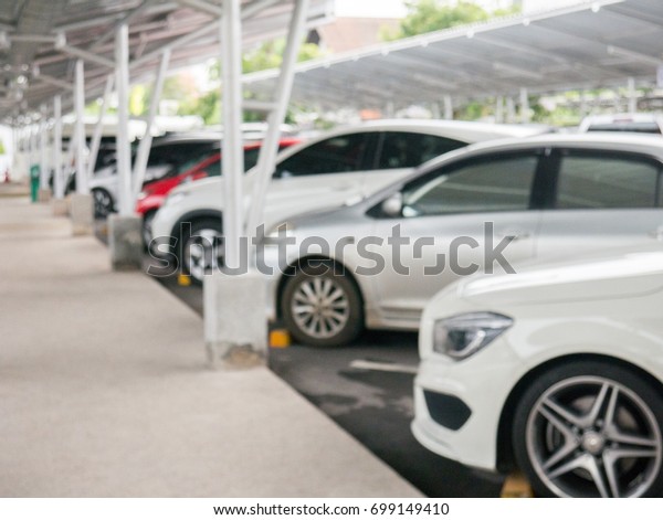 Blurred background of car parking area on\
roof top. Abstract scene of vehicle in\
city