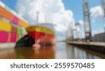 Blurred Background of Cargo Ship Docked at Port Surrounded by Colorful Shipping Containers Under Bright Blue Sky with White Clouds. Blurry Background For Design Projects.