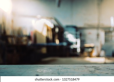 Blurred background of carpentry workshop. Machinery background and table scratched stained table top. Copy space.