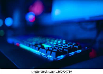 Blurred Background Computer, Keyboard, Blue And Red Lights. Concept ESports Arena For Gamer Playing Tournaments.