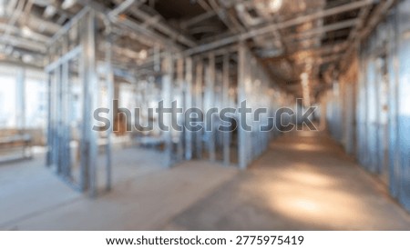 Blurred Background of Construction progress inside a high-rise building lobby with elevator access, showcasing steel framing and uncompleted drywall in a modern urban environment
