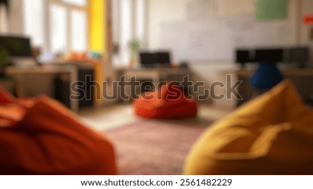 Blurred background of a cozy workspace featuring colorful bean bags and modern office desks, ideal for collaborative learning and fostering creativity in a relaxed environment.