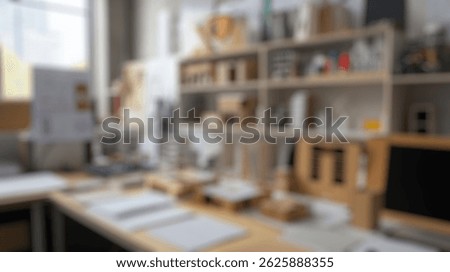 Blurred background of creative workspace of an architect featuring model buildings, sketches, and design materials for urban planning and architectural innovation in a modern studio environment
