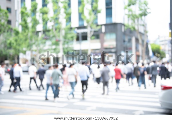 Blurred\
background of crowd anonymous people walking  on pedestrian and \
waiting for traffic light and crossing the street on zebra crossing\
in the city, business centre, Seoul,\
Korea