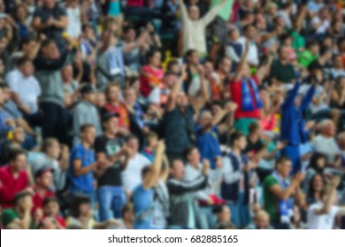 Blurred For Background. A Crowd Of Football Spectators At The Stadium. Visitors Filled Stadium Stands. Soccer Fans In The Stadium.