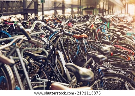 Blurred background of different bicycles in the parking lot, rainy day. Parked bicycles in Amsterdam