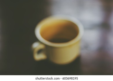blurred background of empty cup of coffee placed on wooden table
