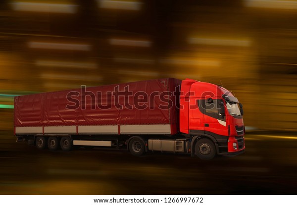 Blurred\
background. Fast moving red truck in the\
tunnel.