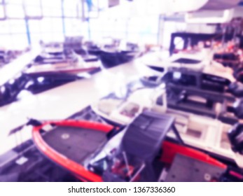 Blurred Background With Fishing Motor Boat In The Dealership Store. Blur Motorboat Showroom Background. Bokeh Light