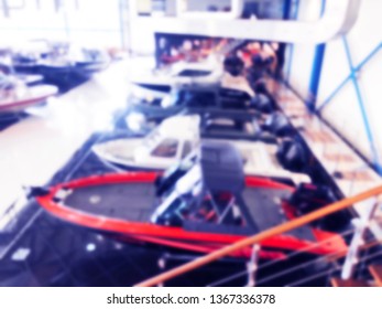 Blurred Background With Fishing Motor Boat In The Dealership Store. Blur Motorboat Showroom Background. Bokeh Light