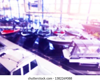 Blurred Background With Fishing Motor Boat In The Dealership Store. Blur Motorboat Showroom Background. Bokeh Light