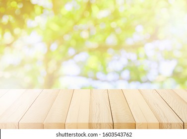 Blurred Background Of Green Park In Summer, Wood Table Top On Shiny Bokeh Green Background. For Product Display