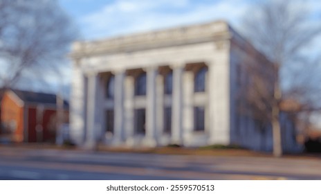 Blurred Background of Historic Stone Building with Columned Facade in Urban Setting Surrounded by Leafless Trees and Clear Blue Sky. Blurry Background For Design Projects. - Powered by Shutterstock