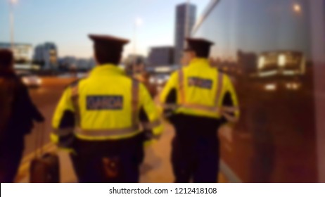 Blurred Background Image Of Irish Police On Street Patrol.