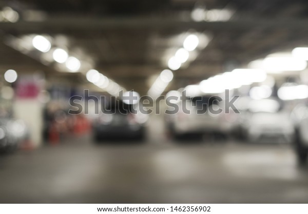 Blurred background of indoor car park with bokeh.\
Abstract blur car park background. Abstract blur car parking in\
shopping mall.