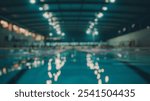 Blurred background of an indoor swimming pool area during a competitive meet, showcasing athletes preparing for diving events. the atmosphere is energetic and focused on performance.