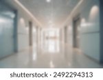 blurred of background. interior of a modern hospital with an empty long corridor. waiting room for patients and families between the corridor with bright white lights. treatment rooms and patient room