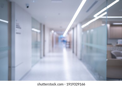 Blurred background of an interior of a modern hospital with an empty long corridor, there are treatment rooms and waiting room for patients and families between the corridor with bright white lights. - Shutterstock ID 1919329166
