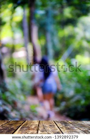 blurred background of landscape with nature and there are two women walking down the mountain.
