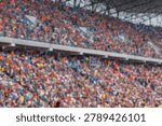 A blurred background of a large crowd of spectators sitting in the stands of a sports stadium during an event.