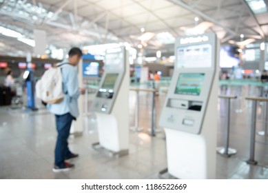 Blurred background of man, passenger using self service check in machine at the international airport