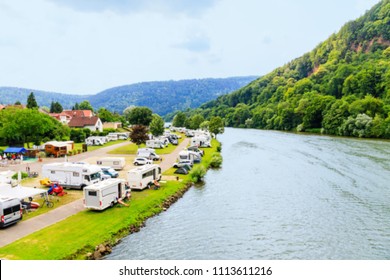 Blurred background with Modern camp site on river Neckar, Germany. Traveling Europe in a motorhome. Family vacation in german caravan park. Caravan camping on  summer beach. 