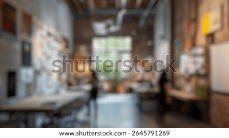 Blurred background of modern creative workspace with exposed brick walls and abundant natural light, featuring collaborative areas, artwork displays, and design tools for inspiration and productivity