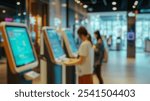 Blurred background of modern high-tech self-service kiosks in a bank lobby area facilitate efficient customer transactions and enhance user experience in a digital environment.